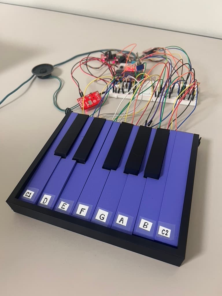 The assembled one-octave keyboard prototype (keys C1 through C2), wired to a breadboard staging the micro:bit, mode-select switch, external ADC, and speaker